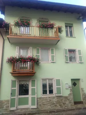 a white building with two balconies and flowers on it at Casa Fiore CIPAT 22038 in Canale San Bovo