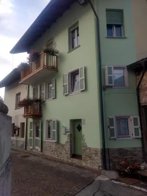 a green and white building with windows and balconies at Casa Fiore CIPAT 22038 in Canale San Bovo