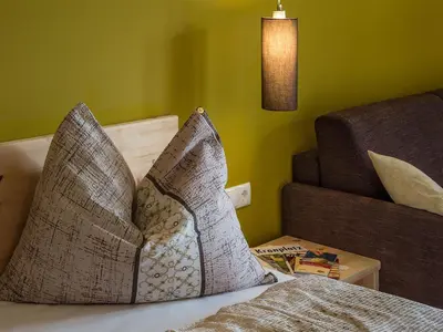 a pillow sitting on top of a bed in a room at Naturhotel Edelweiss in Terento