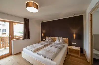 a bedroom with a large bed with a black wall at Naturhotel Edelweiss in Terento