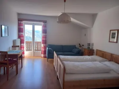 a living room with a bed and a couch at Apartment Lärchenheim in Soprabolzano