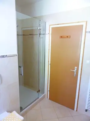 a bathroom with a shower and a glass door at Apartment Lärchenheim in Soprabolzano