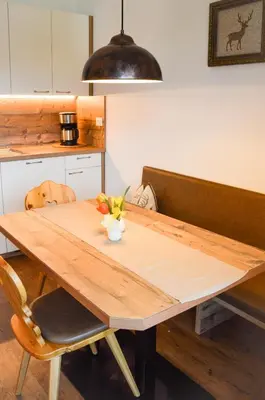a wooden table with flowers on it in a kitchen at Niedermairhof in Falzes