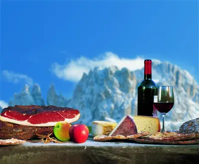 a table with a bottle of wine and a glass at Niedermairhof in Falzes