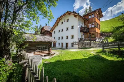 a bedroom with a bed in a room with wooden walls at Lüch da Murin in Badia