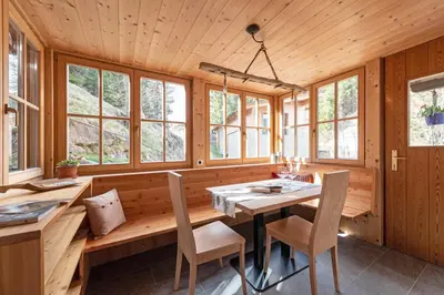 a dining room with a table and two windows at Lüch da Murin in Badia
