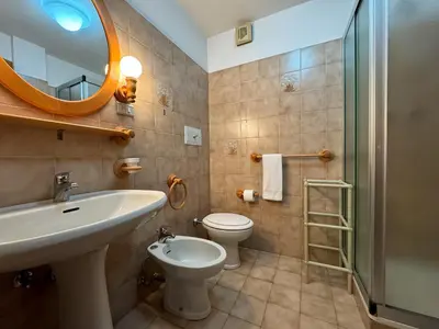a bathroom with a sink and a toilet and a mirror at Family Hut in Carano
