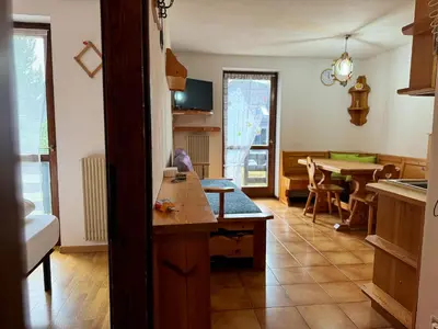 a kitchen with a table and a dining room at Family Hut in Carano