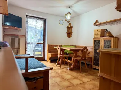 a living room with a table and chairs and a window at Family Hut in Carano