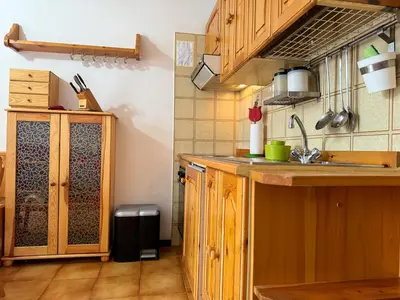 a kitchen with wooden cabinets and a sink at Family Hut in Carano