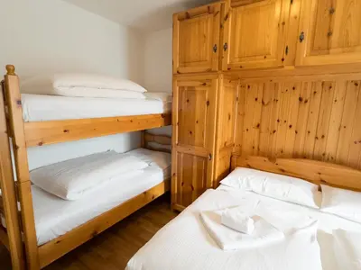 two bunk beds in a room with wooden walls at Family Hut in Carano