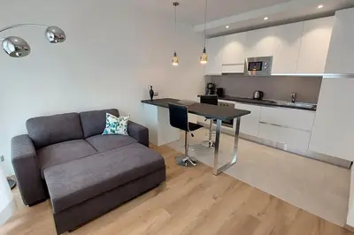 a living room with a couch and a table and a kitchen at Casa Grazia - Merano in Merano