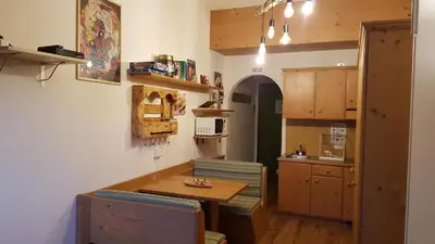 a kitchen with a table and chairs and a kitchen with a counter at Casa Lares in Falcade