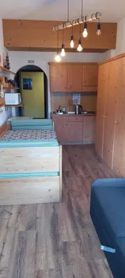 a large room with two beds and a kitchen at Casa Lares in Falcade