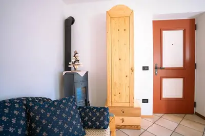 a living room with a couch and a door at Sun & Mountains Cavalese in Cavalese