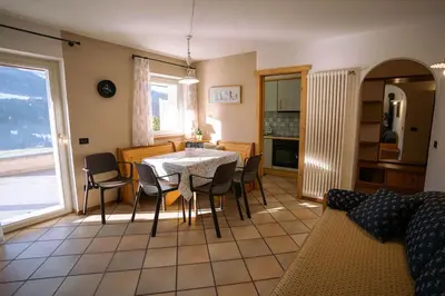 a kitchen and dining room with a table and chairs at Sun & Mountains Cavalese in Cavalese