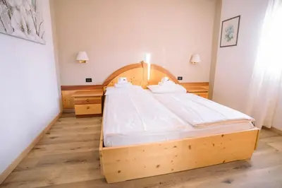 a bedroom with a wooden bed in a room at Sun & Mountains Cavalese in Cavalese