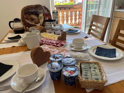 a table with cups and saucers and food on it at Respira il Bosco in Anterivo