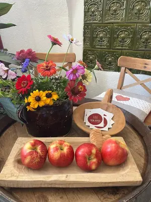 a table with apples on a tray with a vase of flowers at Respira il Bosco in Anterivo
