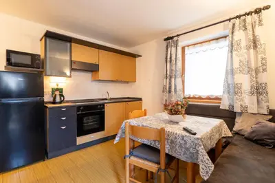 a small kitchen with a table and a table and a room at CASA BRUNELLA in Cavalese