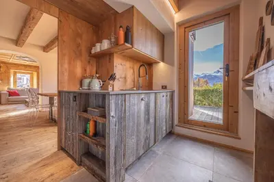 a kitchen with wooden cabinets and a window at Casa Alvera Dream in Cortina dʼAmpezzo