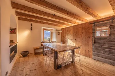a dining room with wooden walls and a table and chairs at Casa Alvera Dream in Cortina dʼAmpezzo