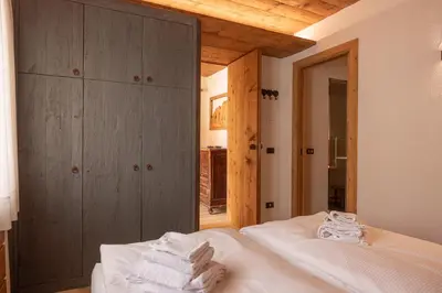 a bedroom with a bed with towels on it at Casa Alvera Dream in Cortina dʼAmpezzo