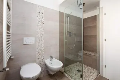 a bathroom with a toilet a sink and a shower at Casa Lucia Moena in Moena