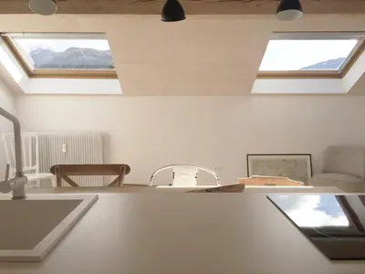 a white kitchen with two skylights in the ceiling at House Design Vipiteno in Vipiteno