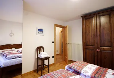 a bedroom with a bed with a blanket on it at CASA DOLOMIA - 3 camere, 2 bagni, parcheggio Dolomiti Affitti in Cavalese