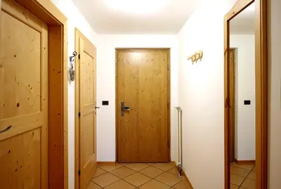 two people walking on a path next to a log cabin at CASA DOLOMIA - 3 camere, 2 bagni, parcheggio Dolomiti Affitti in Cavalese