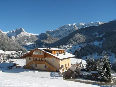 a house on top of a snow covered mountain at Apartments Etruska Gabriela in Santa Cristina in Val Gardena
