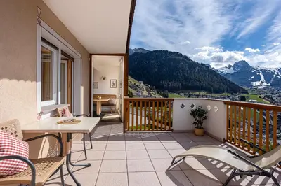 a balcony with a table and chairs and mountains at Apartments Etruska Gabriela in Santa Cristina in Val Gardena