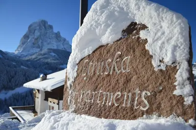 a sign covered in snow in front of a mountain at Apartments Etruska Gabriela in Santa Cristina in Val Gardena
