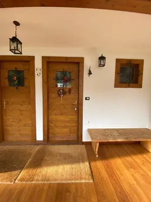 a room with two doors and a wooden bench at Chalet Panorama Dolomiti vicino piste, centro e Cortina in San Vito di Cadore