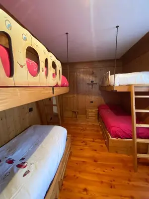 two bunk beds in a room with wooden floors at Chalet Panorama Dolomiti vicino piste, centro e Cortina in San Vito di Cadore