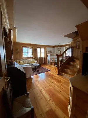 a large living room with wooden floors and stairs at Chalet Panorama Dolomiti vicino piste, centro e Cortina in San Vito di Cadore