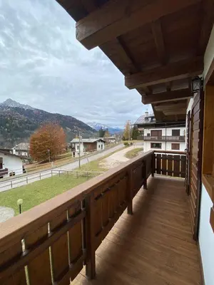 a wooden balcony with a view of a street at Chalet Panorama Dolomiti vicino piste, centro e Cortina in San Vito di Cadore
