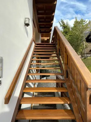 a staircase leading up to a house with wooden railings at Chalet Panorama Dolomiti vicino piste, centro e Cortina in San Vito di Cadore