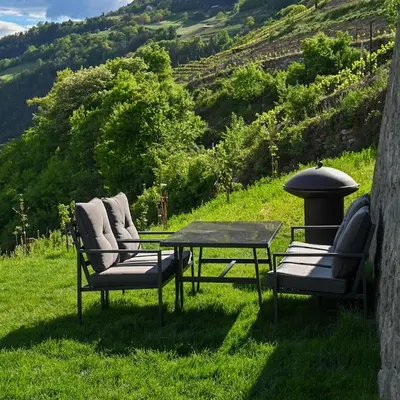 three chairs and a table on a field of grass at Pitzoler Hof in Albes