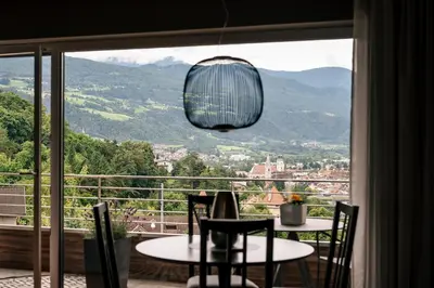 a room with a table and chairs and a large window at Cityview Brixen in Bressanone