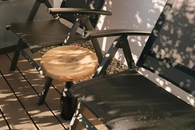 two chairs and a wooden stool on a balcony at Cityview Brixen in Bressanone