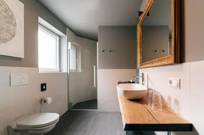 a bathroom with a sink and a toilet and a mirror at Cityview Brixen in Bressanone