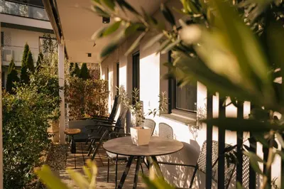 an outdoor patio with tables and chairs and plants at Cityview Brixen in Bressanone
