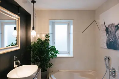 a bathroom with a sink and a tub and a window at Cityview Brixen in Bressanone