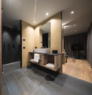 a bathroom with a sink and a mirror at DOLOMITI EXCLUSIVE YOUR MOUNTAIN SUITE in Pozza di Fassa