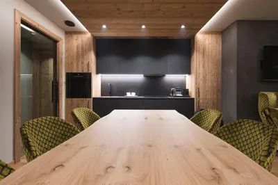 a conference room with a wooden table and chairs at DOLOMITI EXCLUSIVE YOUR MOUNTAIN SUITE in Pozza di Fassa