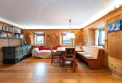 a dining room with a table and chairs and a bed at Apartments Frea - Vedl Luech da Plajes in Ortisei