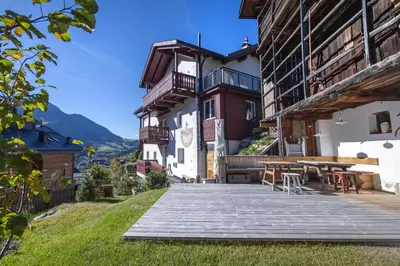 a patio with a table and chairs in front of a building at Apartments Frea - Vedl Luech da Plajes in Ortisei