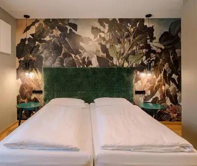 a bedroom with two beds and a floral wallpaper at The Nest – 85 qm apartment - Mountain, Ski, Relax in Vila di Sopra